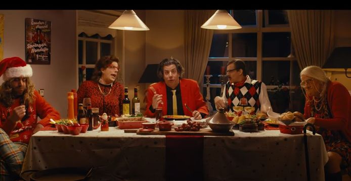 Snollebollekes zit met de hele familie aan het kerstdiner in de clip van zijn nummer 'Beuk de ballen uit de boom'.