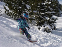 Evy Poppe als klein meisje in actie op het snowboard.