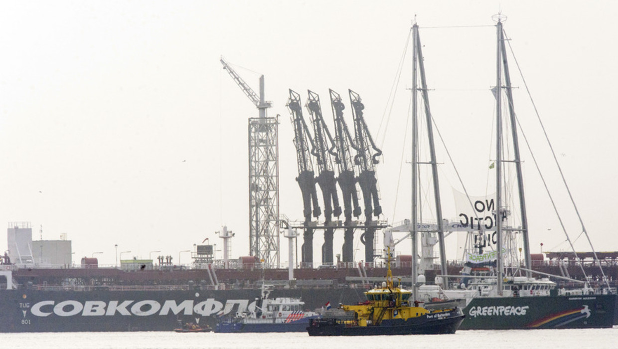 De Rainbow Warrior van Greenpeace ligt bij de Russische olietanker Michail Oeljanov (achtergrond), gevuld met de omstreden Noordpoololie, in de Maasvlakte Olie Terminal. Beeld anp