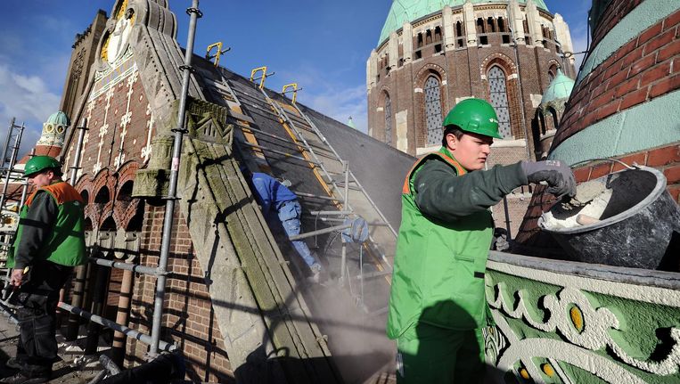 Metselaar bezig met restauratie Sint Bavo-basiliek in Haarlem. Beeld Marcel van den Bergh/de Volkskrant