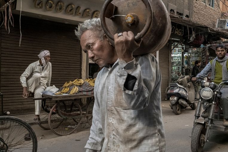 Een arbeider met een gasfles in New Delhi. India twijfelt niet om alle Russische olie die het nodig heeft goedkoop te importeren. Beeld NYT