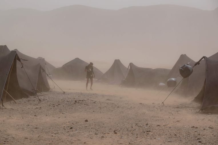 Een deelnemer aan de Marathon des Sables (Marathon van het Zand) probeert in de Sahara in centraal-Marokko zijn weg te vinden in het tentenkamp waar de deelnemers verblijven. Beeld AFP