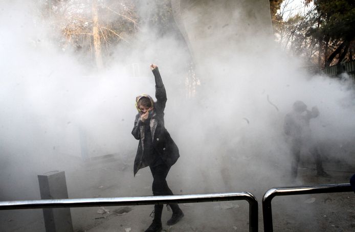 Een Iraanse studente beschermt haar gezicht tegen het traangas dat de oproerpolitie verspreidt. De foto werd 30 december gemaakt, maar de protesten gaan nog steeds door.