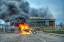 Brandende auto voor het station.