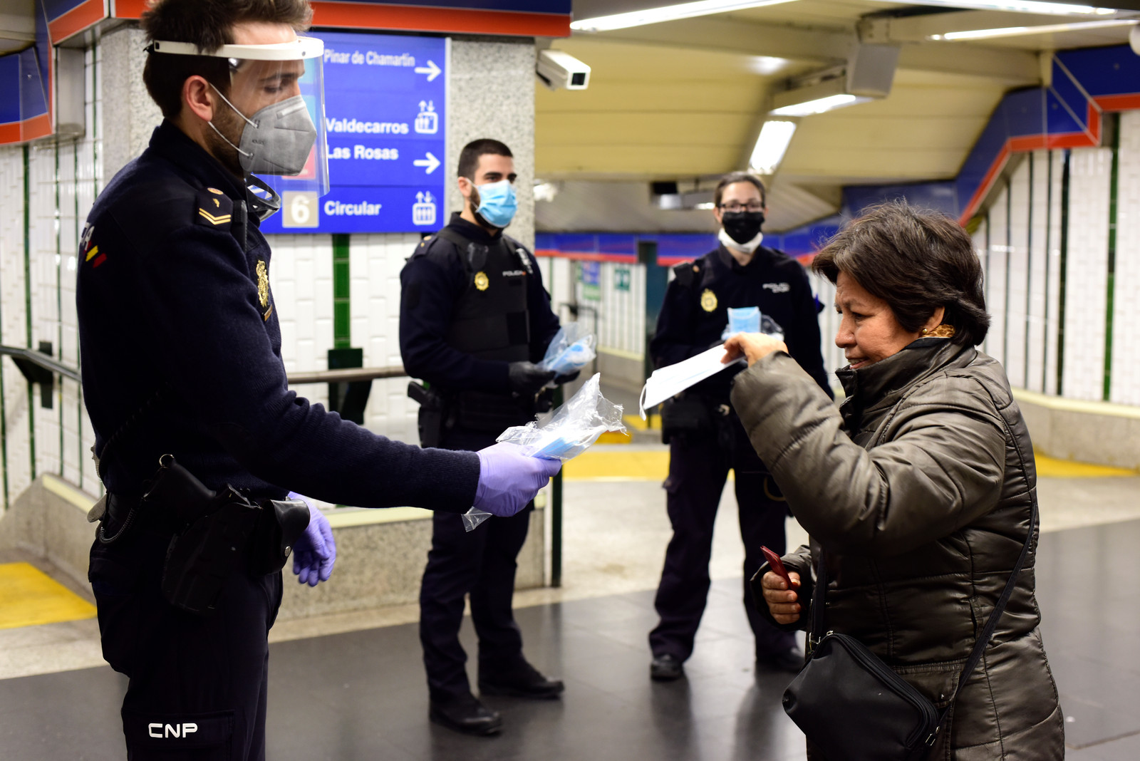 In een Madrileens metrostation deelt de politie mondkapjes uit. Beeld Getty Images