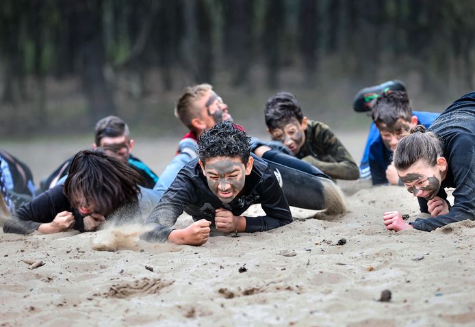 Leerlingen van basisschool Silvester-Bernadette tijgeren door het zand in de Bakelse bossen.