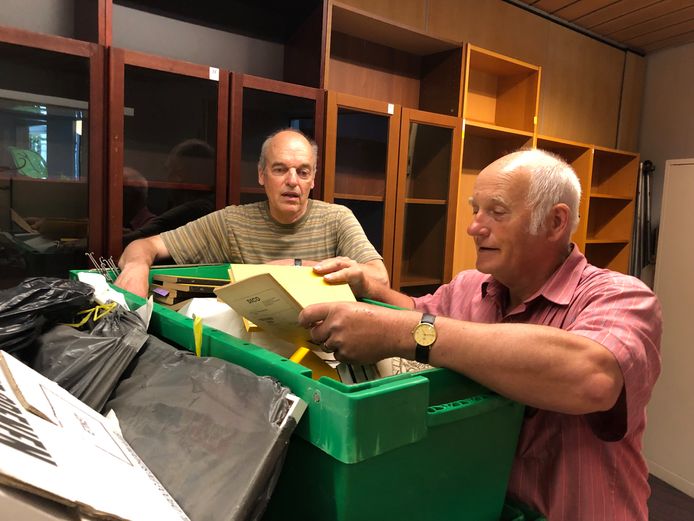 Op de nieuwe locatie in Haaren werpt waarnemend voorzitter Anton van Dorp (L) van Heemkundekring De Kleine Meijerij met verhuiscoördinator Gerard Willems (R) een blik in de boeken en papieren die al verhuisd zijn