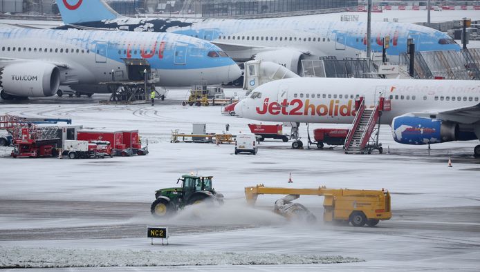 A snowplow at work on taxi lanes at Manchester Airport.