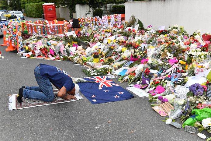 Een moslim bidt voor de bloemenzee voor de Al Noor-moskee in Christchurch.