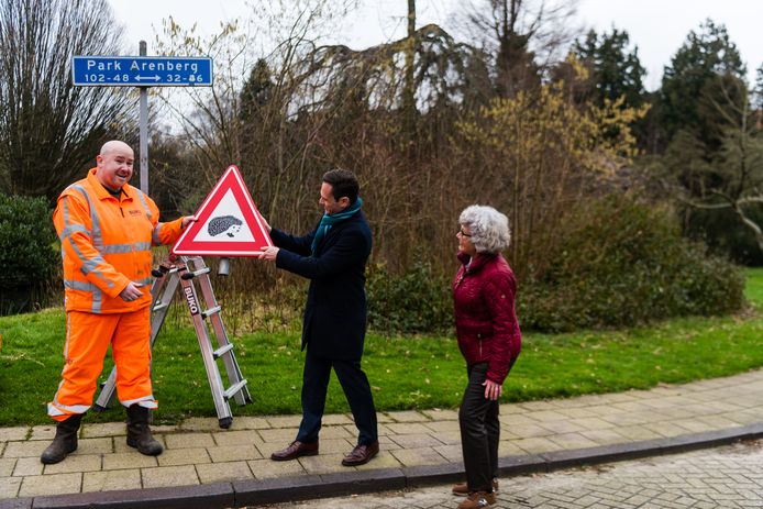 Burgemeester Potters van De Bilt en Charlotte Olthof plaatsen samen een van de nieuwe egeltjesborden. De oude borden zijn  gestolen.