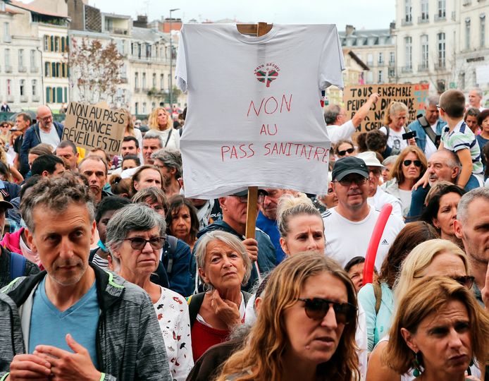Demonstranten houden borden omhoog met slogans zoals 'non au pass sanitaire' (nee aan de gezondheidspas).