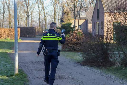Een politieman loopt met een warmtecamera langs vakantiewoningen op recreatiepark De Groene Heuvels in Ewijk, tijdens een grootscheepse controle van politie, gemeente Beuningen en de Belastingdienst.