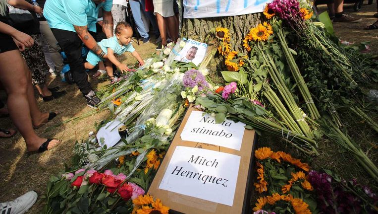 Deelnemers aan de stille tocht voor Mitch Henriquez leggen bloemen in het Zuiderpark. Beeld anp