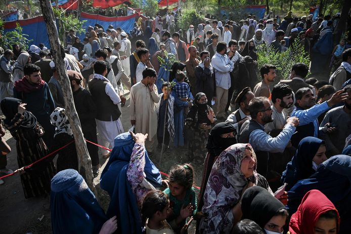 Afghaanse families die zijn gevlucht voor de gevechten tussen de Taliban en Afghaanse troepen verzamelen voedsel in Kaboel