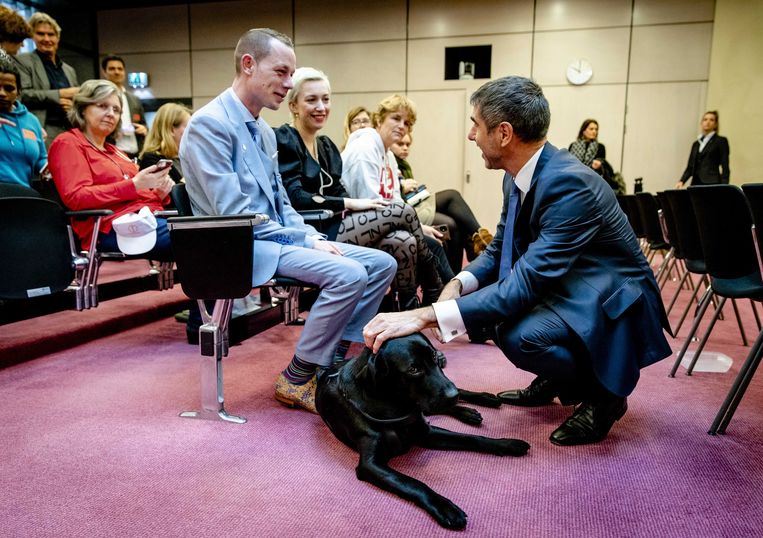 Paul Blokhuis, staatssecretaris van Volksgezondheid, Welzijn en Sport, begroet hond Bobby van Charlotte Bouwman voorafgaand aan een algemeen overleg in de Tweede Kamer over de geestelijke gezondheidszorg. Beeld ANP