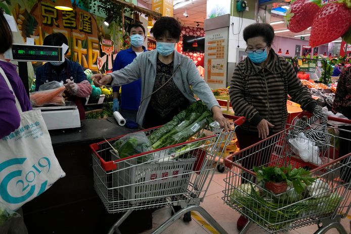 Bewoners van het Chaoyang-district slaan in een supermarkt bladgroenten in.