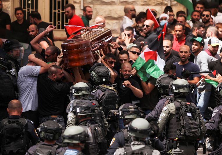 Israëlische politieagenten voeren charges uit op Palestijnen die de grafkist dragen. Beeld REUTERS