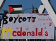 Een demonstrant houdt een spandoek omhoog met de tekst 'Boycott McDonald's'.