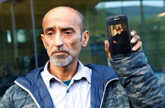 Omar Nabi met een foto van zijn vader die omkwam in de terreuraanslag. 