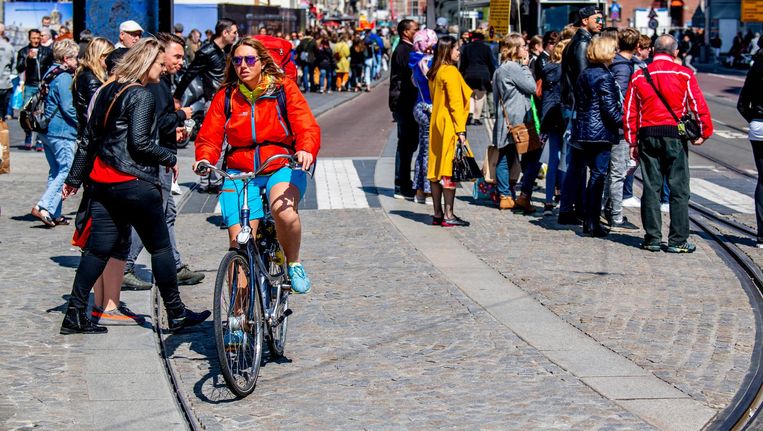 Voetgangers, fietsers en een tram in de drukke binnenstad van Amsterdam Beeld anp
