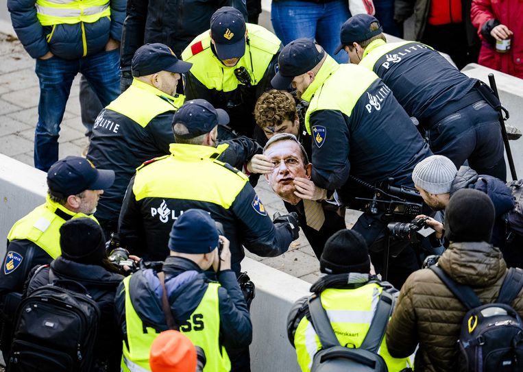 De politie grijpt in bij een demonstrant met een masker van Jeroen van der Veer (oud-CEO Shell) tijdens de demonstratie van klimaatactiegroep Extinction Rebellion bij de A12. Beeld ANP