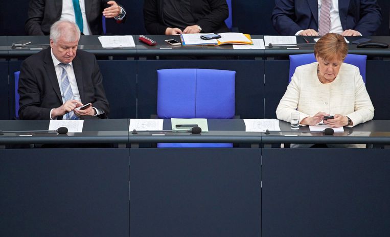 Minister van binnenlandse zaken Horst Seehofer en bondskanselier Angela Merkel in het Duitse parlement. Beeld EPA