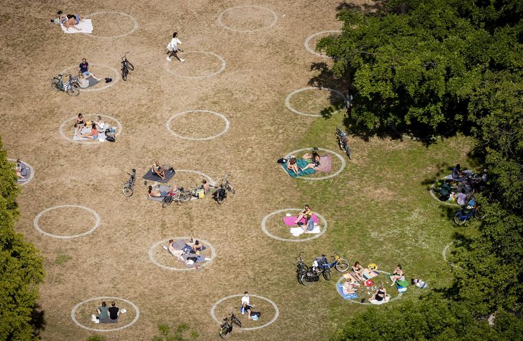 Mensen genieten van de zon in het Rotterdamse Vroesenpark, het park bij de Euromast.  Beeld ANP
