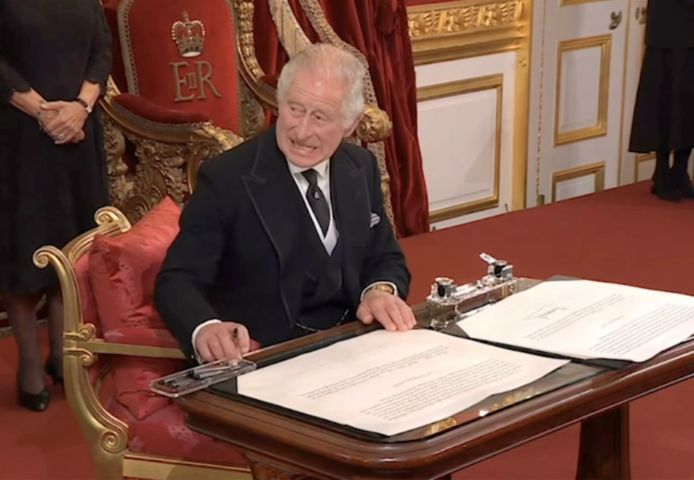 Koning Charles reageert geïrriteerd wanneer enkele pennen in de weg liggen tijdens het tekenen van de Accession Proclamation.
