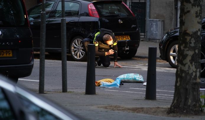 Een agent doet na de schietpartij onderzoek in de Allard Piersonstraat.