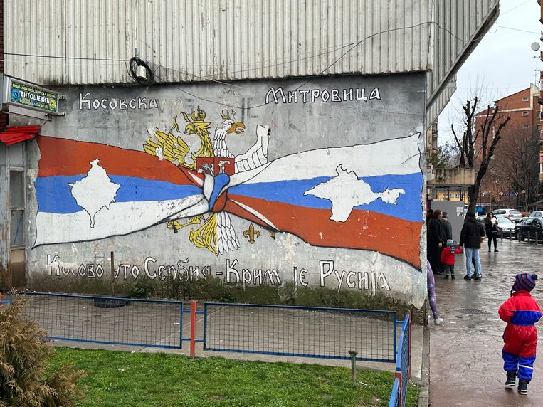 Op deze muurschildering in Noord-Mitrovica zijn de vlaggen van Rusland en Servië verknoopt met de tekst “Kosovska Mitrovica - Kosovo is Servië, De Krim is Rusland”. Beeld Thijs Kettenis