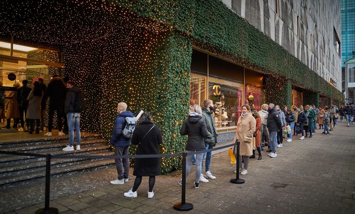 Lange rijen winkelend publiek bij de Bijenkorf.