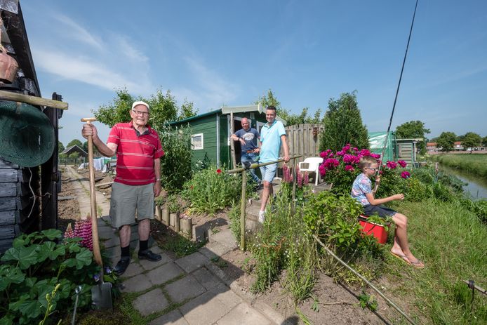 Teus Ouwersloot (l), Cornee de Ruiter (r) en Jente van der Steen (m) op het perceel van Ouwersloot op het volkstuincomplex De Praetakker te Heukelum. Cornees zoon is aan het vissen.