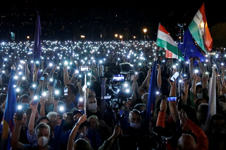 Demonstranten in Boedapest houden hun telefoons met het lampje aan omhoog uit protest tegen het ontslag van de hoofdredacteur van nieuwssite Index.  Beeld Reuters, Bernadett Szabo
