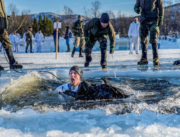 Leden van het Korps Mariniers zwemmen een stukje in door het ijswater tijdens een wintertraining in Noorwegen.
