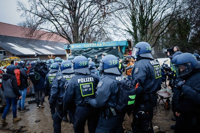 Politieagenten staan tegenover klimaatactivisten aan de rand van Lutzerath.