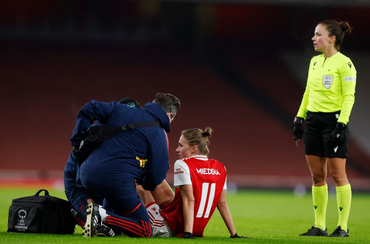 Vivianne Miedema zit op de grond en realiseert zich al snel dat ze een zware knieblessure heeft opgelopen, op 15 december tijdens Arsenal-Olympique Lyon in het Emirates Stadion in Londen.  Beeld Action Images via Reuters