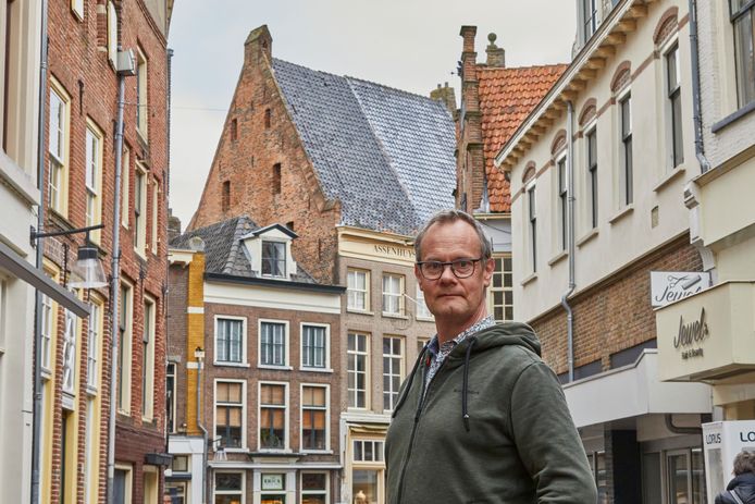 Stadsarcheoloog Michiel Groothedde, met op de achtergrond het statige Assenhuys.