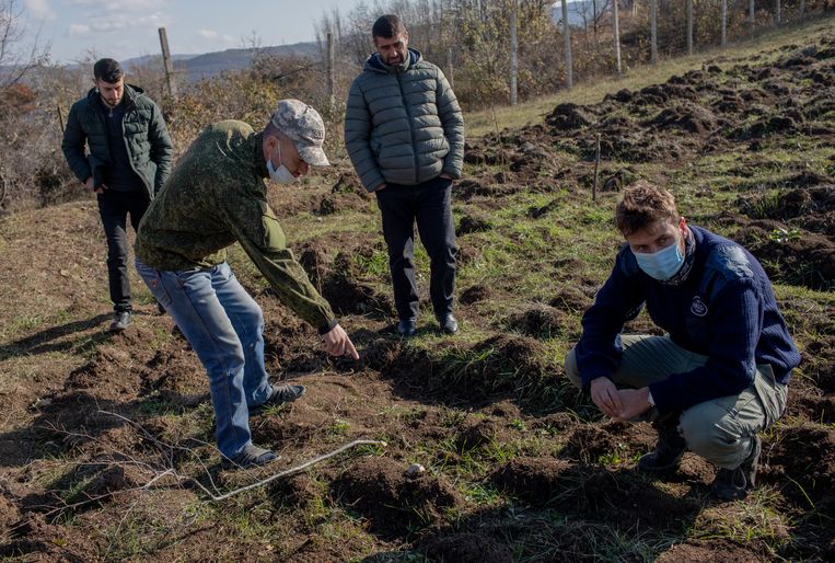 Khachatur Balasanyan, inwoner van de hoofdstad Stepanakert, wijst naar een explosief op zijn terrein. Rechts Koen van der West. Beeld Anush Babajanyan