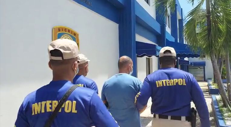 Agenten van Interpol brengen Marc Biart weg in Boca Chica, Dominicaanse Republiek. Beeld ITALIAN POLICE VIA REUTERS