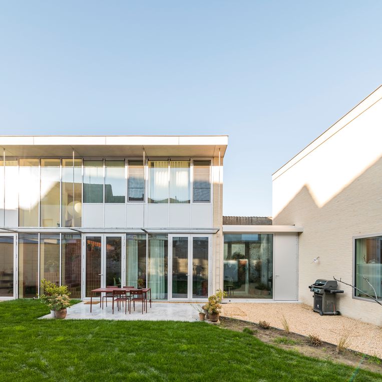 The south-facing side wall of the house is almost entirely made of glass.  