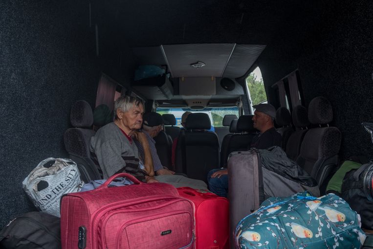Inwoners verzamelen in het busje van Sergej voor evacuatie.  Beeld Vincent Haiges