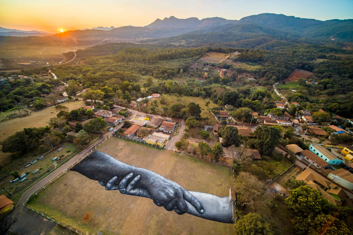 De Franse kunstenaar Saype heeft in de Braziliaanse plaats Brumadinho een eerbetoon gemaakt voor de slachtoffers van de mijnbouwramp in 2019.  Beeld AFP