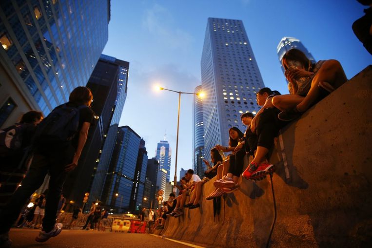 Demonstranten blokkeren de hoofdstraat van het financiële district in Hongkong. Beeld REUTERS