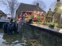 De eigenaresse spreekt sussende woorden om haar paard gerust te stellen, terwijl de brandweer een strategie bedenkt om de merrie te redden.