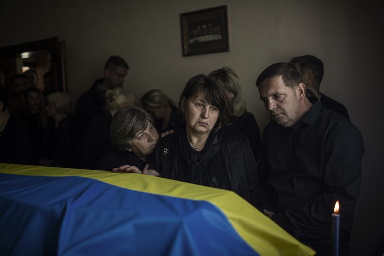 Familieleden rouwen bij de kist van een overleden Oekraïense soldaat. Beeld van expositie Framing the War. Beeld ANP/The New York Times Syndication