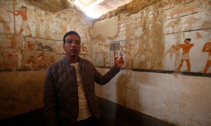 Een gids van het ministerie van Oudheden toont de wandversieringen in het graf van Haptet