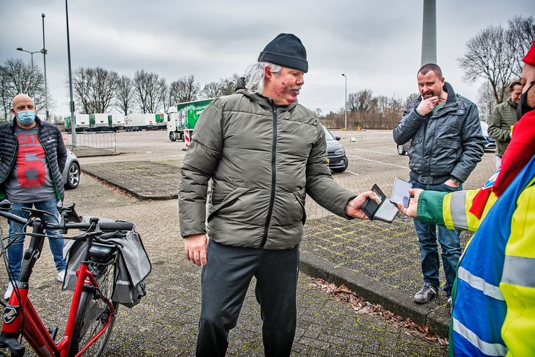 Werknemers van Heineken laten zich, met een app, registreren als staker, op de parkeerplaats van de brouwerij in Zoeterwoude.  Beeld Guus Dubbelman / de Volkskrant