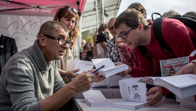 Andrej Babis signeert tijdens zijn campagne in Praag zijn boek Wat ik droom als ik tijd heb om te slapen. Beeld EPA