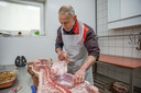 Slager Bram de Waard legt uit van welke delen van een varken hij stroopvet maakt.