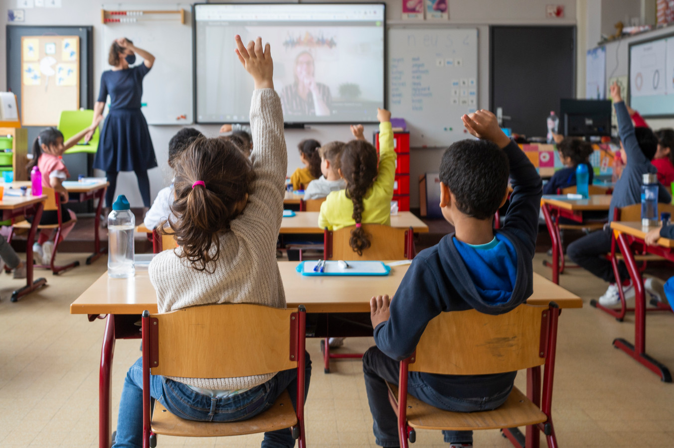 Bij basisschool De Piramide zitten de leerkrachten in quarantaine, de leerlingen krijgen les via webcam als de leerkracht thuis zit. Juf Kim gaf les vanuit haar woonkamer, terwijl medewerkster van het Stedelijk Onderwijs en oud-leerkracht Els in de klas stond.